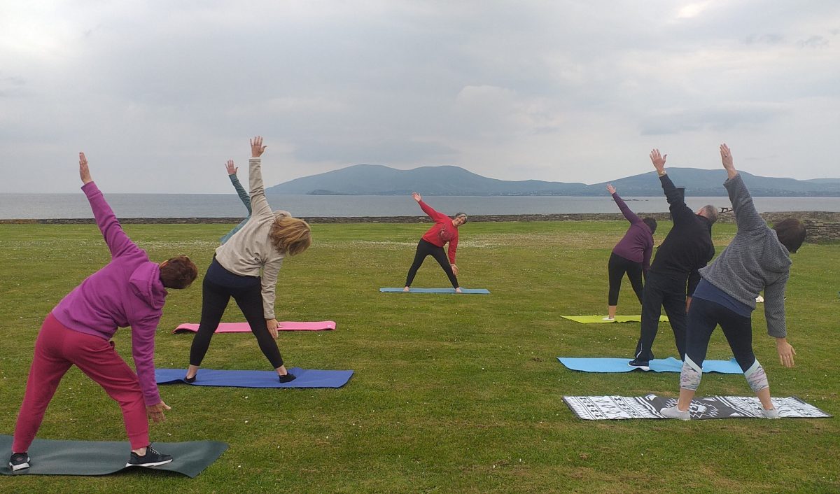 Yoga class on the grass with mountain in the background